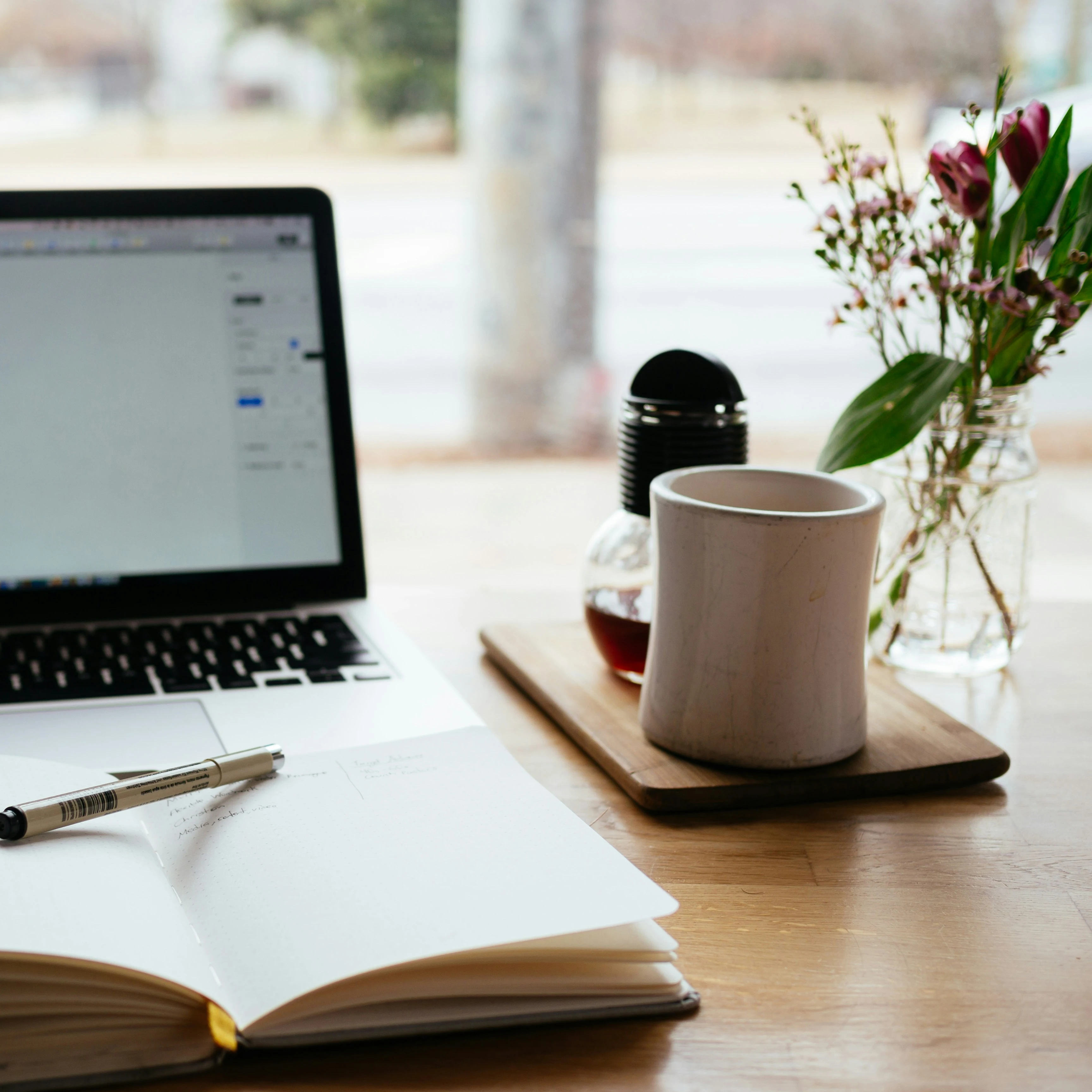 notebook, laptop and flower on the desk